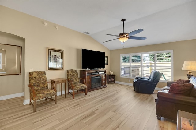 living room featuring lofted ceiling, visible vents, light wood-style flooring, a ceiling fan, and baseboards