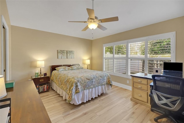 bedroom featuring light wood-type flooring, multiple windows, ceiling fan, and baseboards