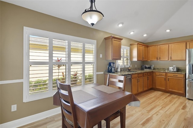 kitchen featuring appliances with stainless steel finishes, light wood-type flooring, a healthy amount of sunlight, and a sink