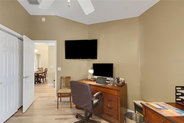 home office featuring baseboards, visible vents, a ceiling fan, vaulted ceiling, and light wood-style floors