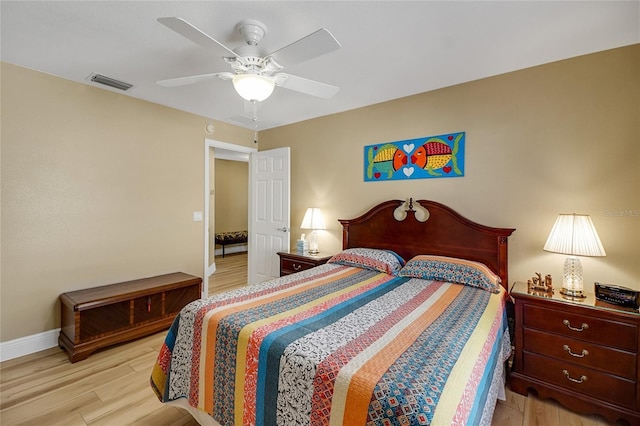 bedroom with baseboards, ceiling fan, visible vents, and light wood-style floors