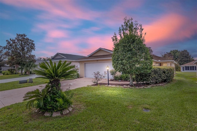 view of front of house with a garage, driveway, a front yard, and stucco siding