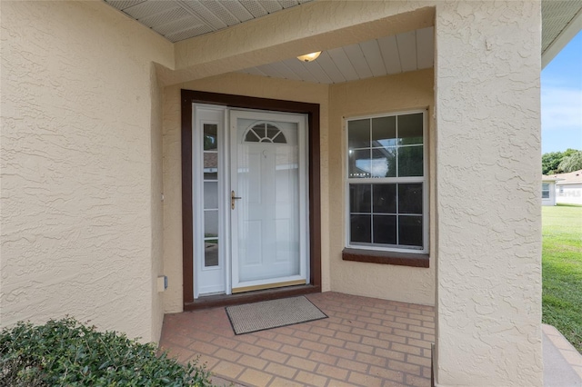 entrance to property featuring stucco siding