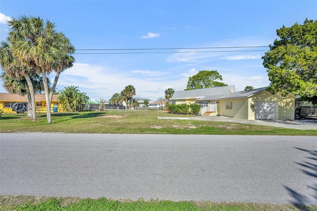 view of front of house with concrete driveway, a front lawn, and an attached garage