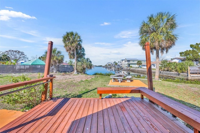 deck featuring a yard, a water view, and fence