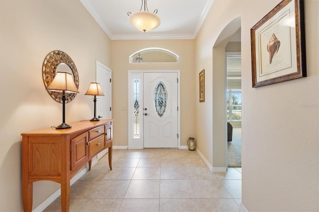 entrance foyer featuring arched walkways, crown molding, baseboards, and light tile patterned floors