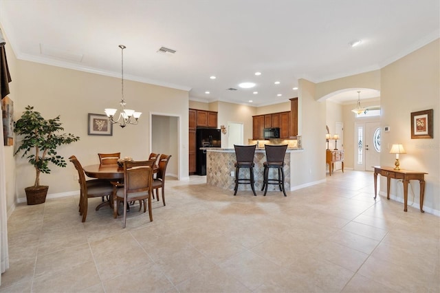 dining space with baseboards, visible vents, arched walkways, and crown molding