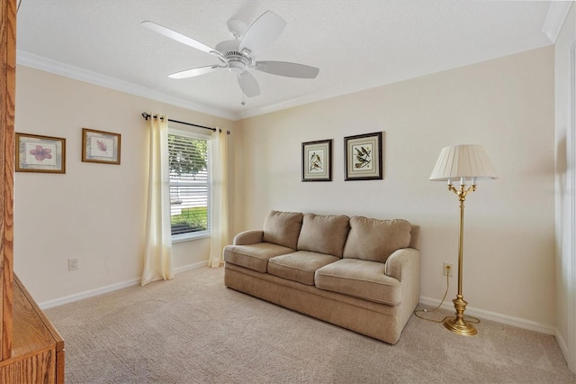 living room with carpet floors, crown molding, baseboards, and ceiling fan