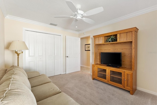 living room featuring crown molding, visible vents, a ceiling fan, and light colored carpet