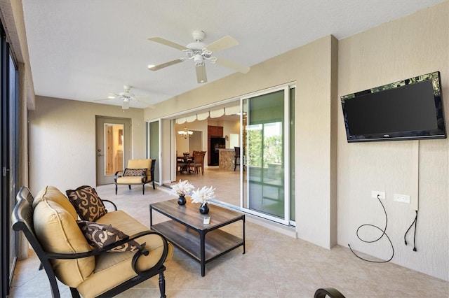 living area with light tile patterned floors and ceiling fan with notable chandelier