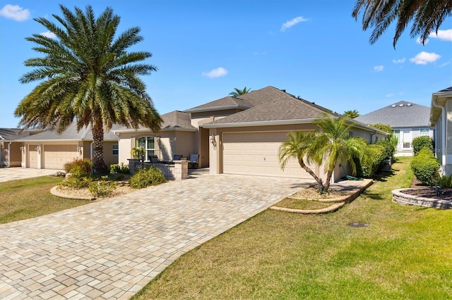 view of front of home with a garage, a front lawn, decorative driveway, and stucco siding