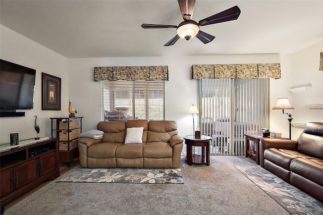 living area featuring carpet floors, a ceiling fan, and a healthy amount of sunlight