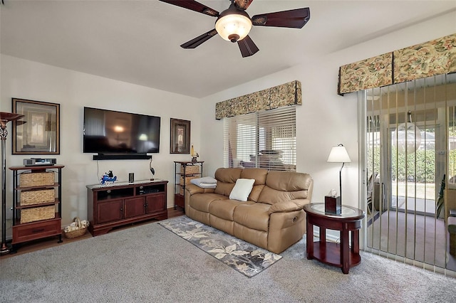 carpeted living area featuring a ceiling fan