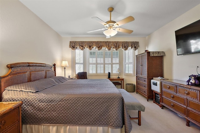 bedroom with a ceiling fan and light carpet