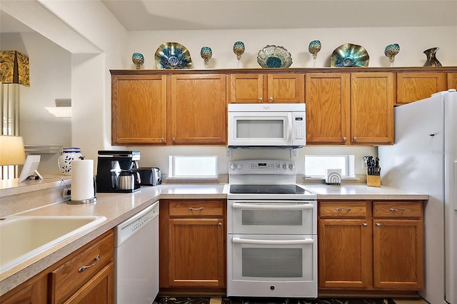 kitchen featuring brown cabinetry, white appliances, and light countertops