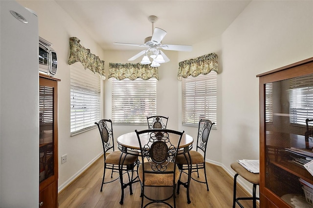 dining area featuring a ceiling fan, plenty of natural light, and light wood-style flooring