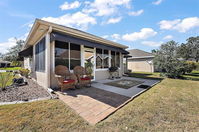 back of property featuring a patio area, a sunroom, and a lawn