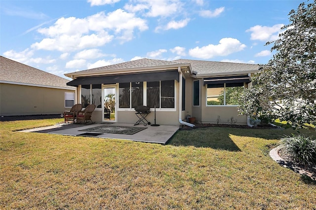 rear view of property featuring stucco siding, a shingled roof, a lawn, a sunroom, and a patio area