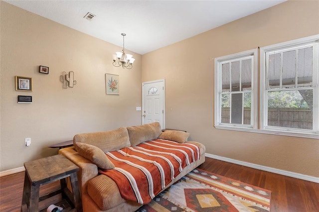 bedroom featuring an inviting chandelier, baseboards, and wood finished floors