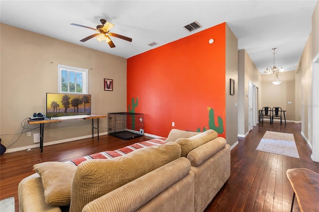 living room featuring baseboards, visible vents, hardwood / wood-style floors, and ceiling fan with notable chandelier