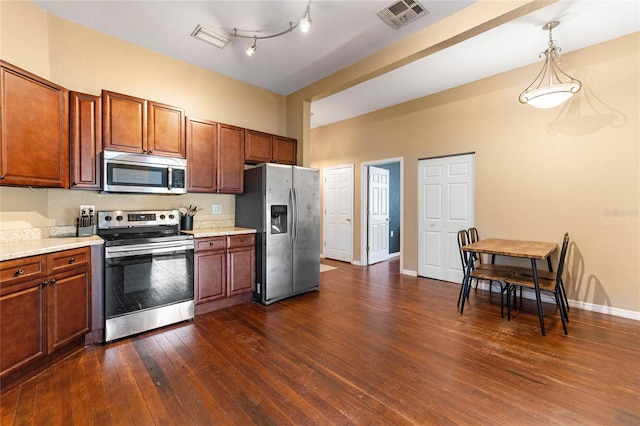 kitchen with appliances with stainless steel finishes, light countertops, visible vents, and dark wood-style floors