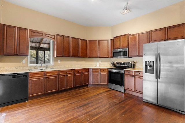 kitchen with stainless steel appliances, dark wood-style flooring, a sink, and light countertops