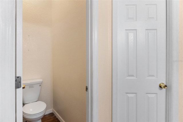 bathroom featuring baseboards and toilet