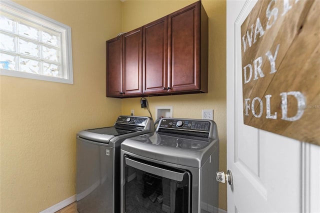 laundry area with baseboards, cabinet space, and washer and dryer