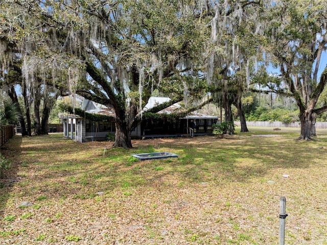 view of yard with a sunroom and fence