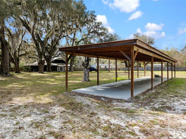 view of community featuring a detached carport and a yard