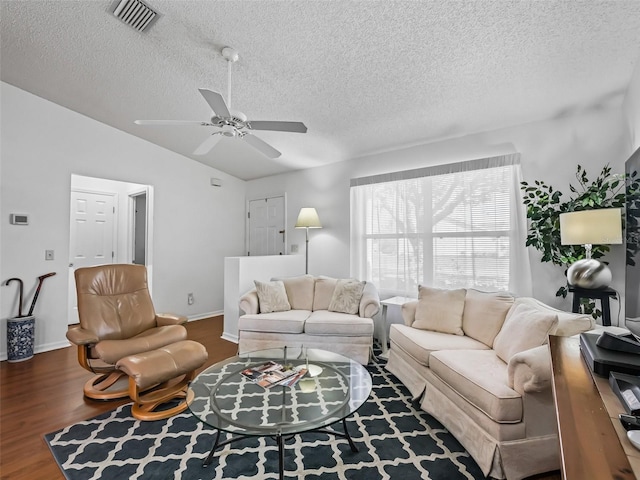 living room with visible vents, a ceiling fan, vaulted ceiling, a textured ceiling, and wood finished floors