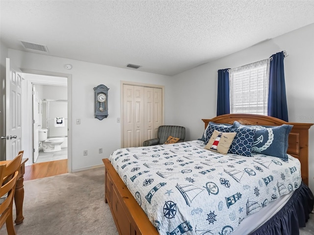 bedroom with light colored carpet, a closet, visible vents, and a textured ceiling