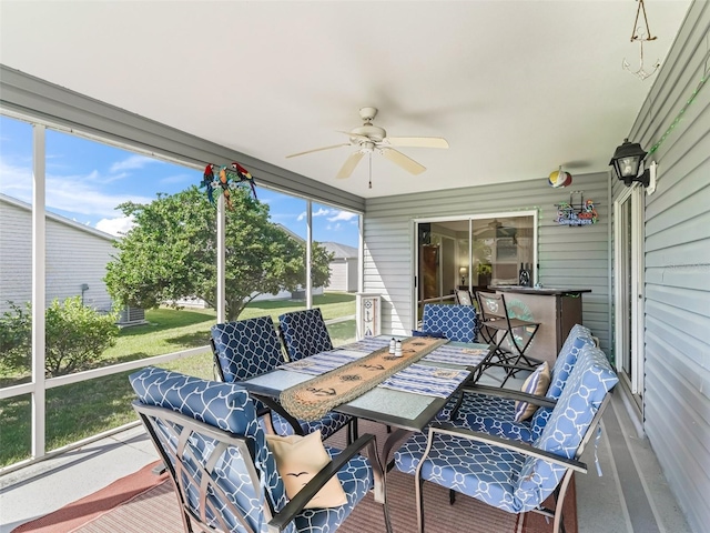 sunroom / solarium featuring a ceiling fan