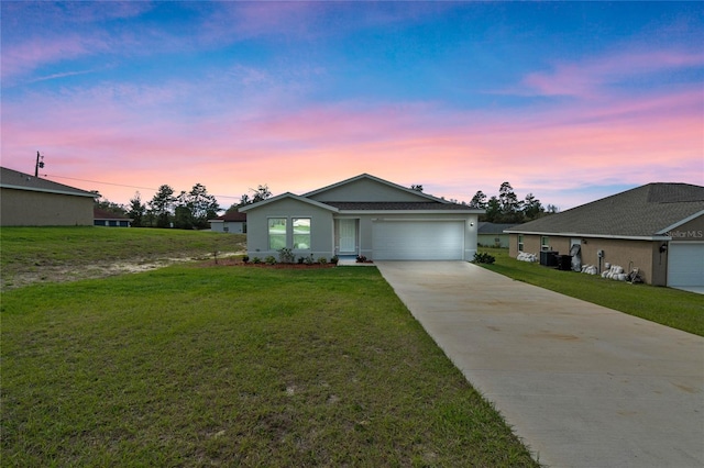 ranch-style house with a garage, driveway, and a lawn