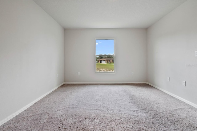 unfurnished room featuring carpet floors and baseboards