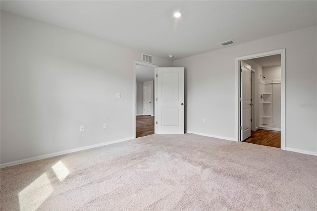 unfurnished bedroom with carpet, visible vents, and baseboards