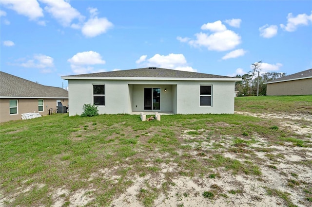 back of property featuring a lawn and stucco siding