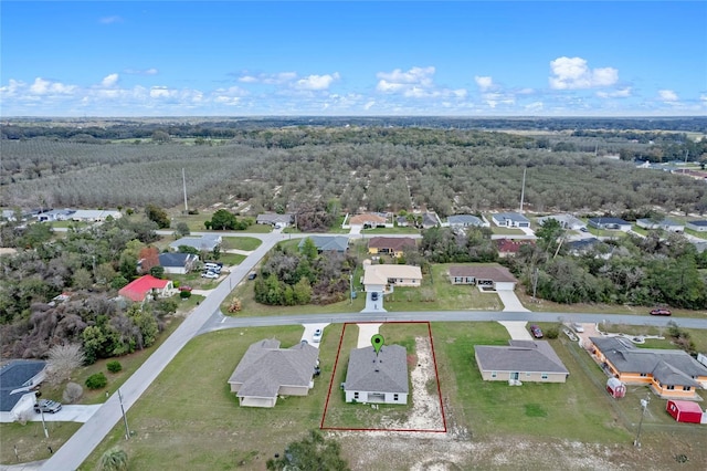 drone / aerial view featuring a residential view and a view of trees