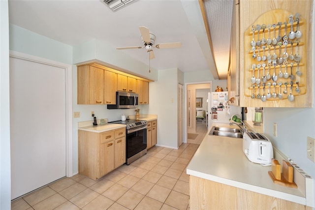 kitchen with light tile patterned floors, light brown cabinets, a sink, visible vents, and appliances with stainless steel finishes