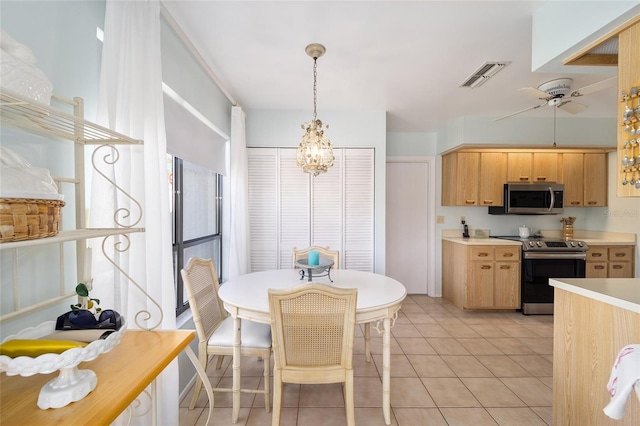 kitchen featuring light tile patterned floors, ceiling fan with notable chandelier, visible vents, light countertops, and appliances with stainless steel finishes