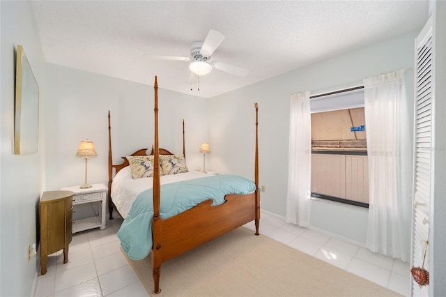 bedroom with tile patterned flooring, ceiling fan, and a textured ceiling