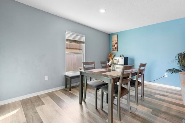 dining room with light wood-type flooring and baseboards