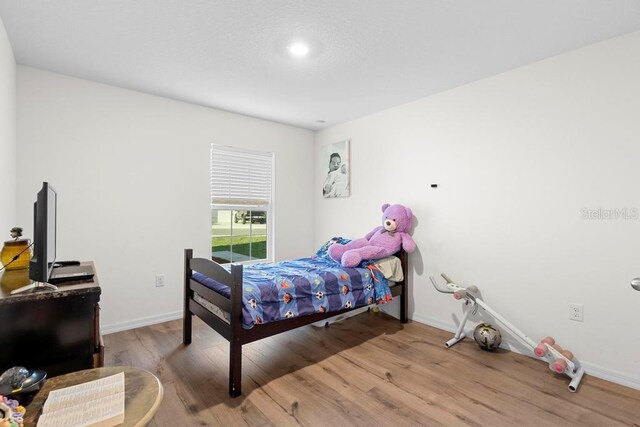 bedroom featuring wood finished floors and baseboards