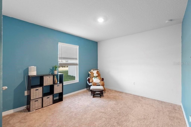 living area with a textured ceiling, baseboards, and carpet flooring