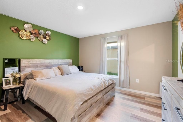 bedroom with light wood-style flooring and baseboards