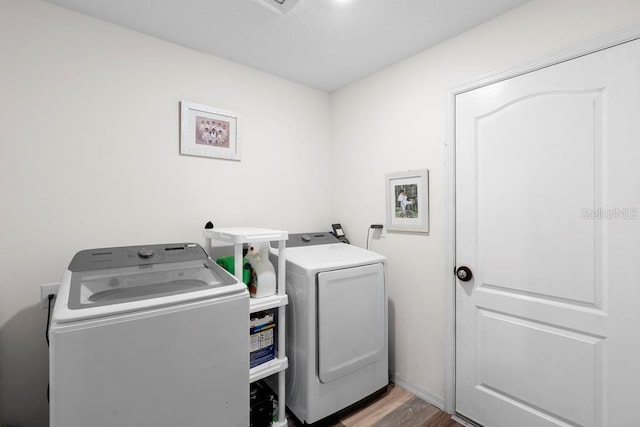 washroom featuring laundry area, washer and clothes dryer, and wood finished floors