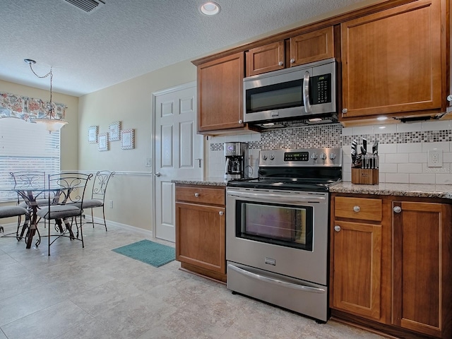 kitchen featuring stainless steel appliances, decorative backsplash, and brown cabinets