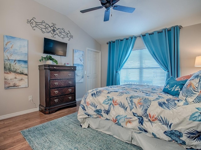 bedroom featuring a ceiling fan, baseboards, vaulted ceiling, and wood finished floors