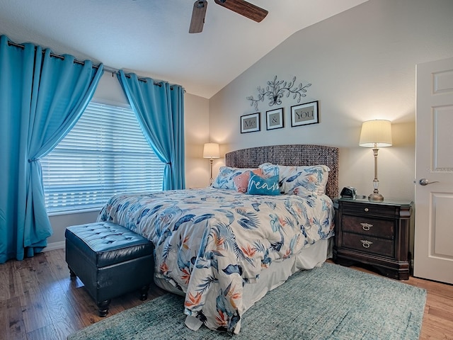 bedroom with ceiling fan, vaulted ceiling, and wood finished floors