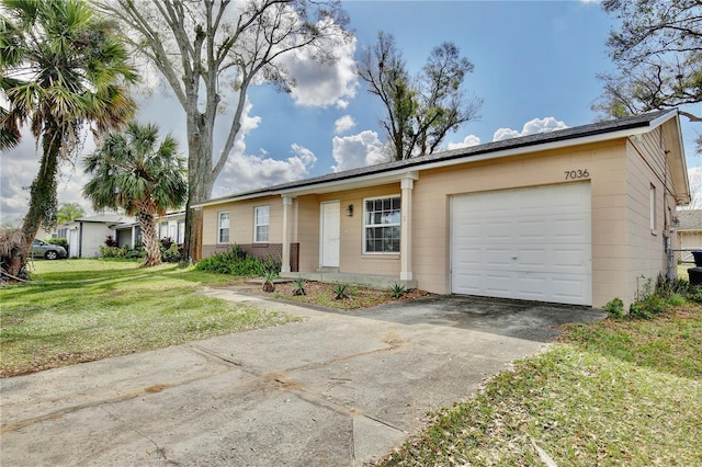 ranch-style home featuring an attached garage, concrete driveway, and a front yard